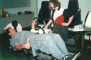 Jane Mitchell with Ken Caminiti lying down in a doctor's chair during an exam.