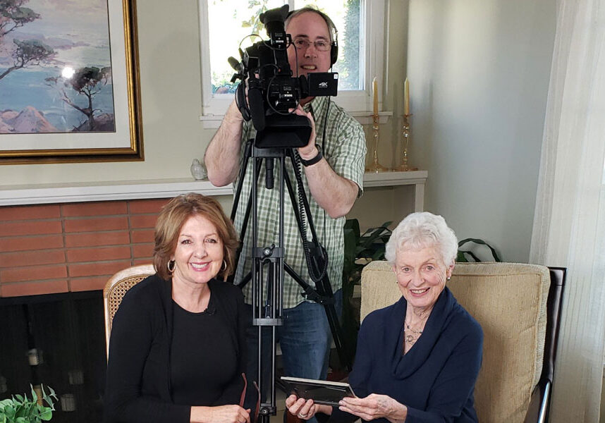 Jane poses with Ann and cameraman Dan during a video interview in her home.